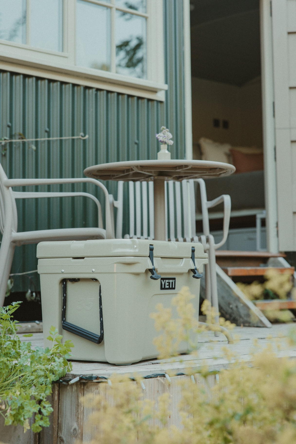 Fern - deck with cool box, chairs and small table beside the open hut door
