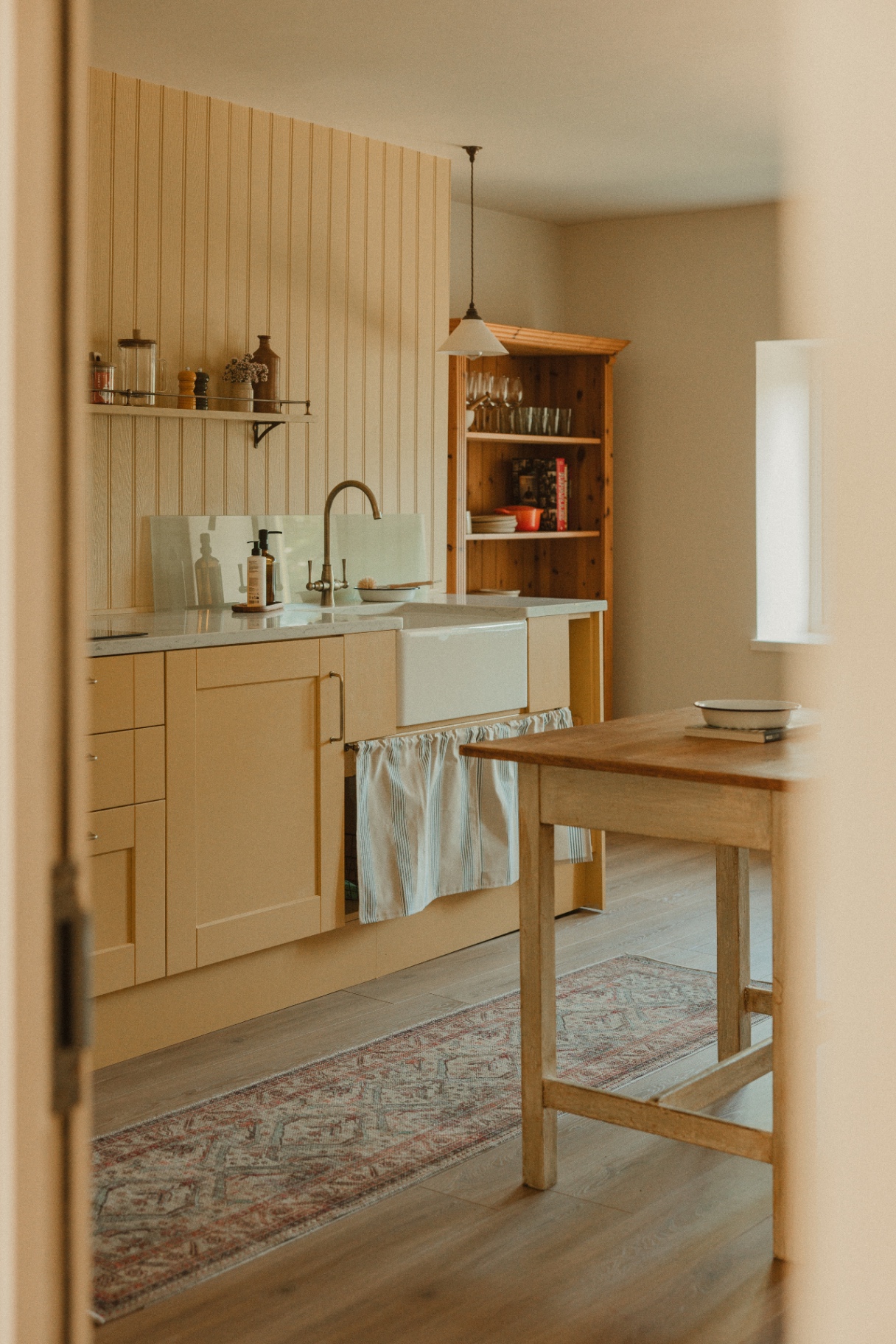 The Guesthouse - light-filled kitchen with butler sink, wooden dresser and country details