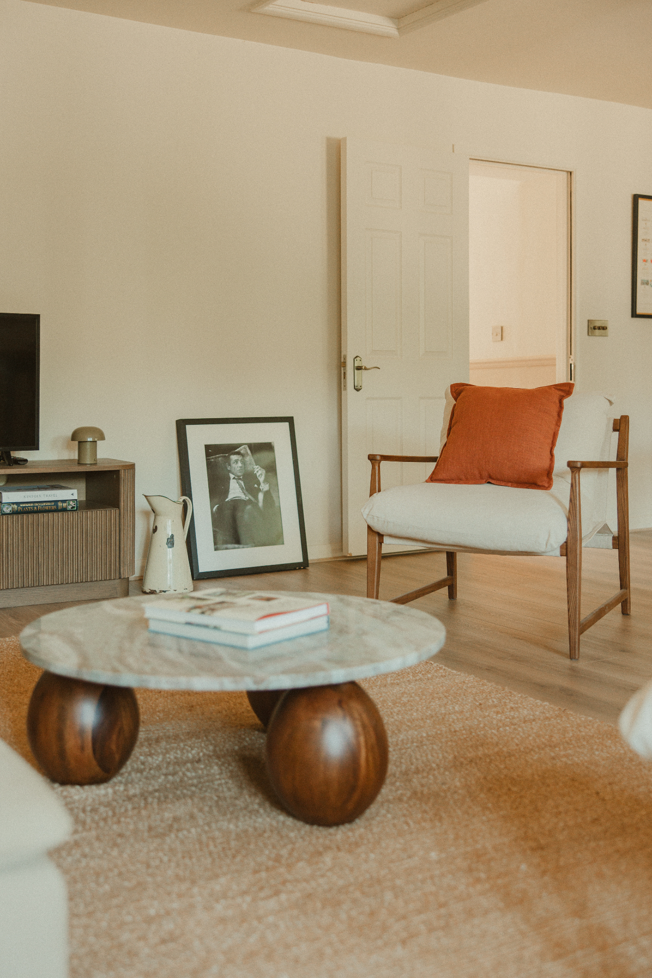 The Guesthouse - relaxed living room with armchair, artwork and natural textures